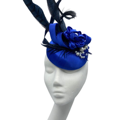 Small blue satin button headpiece with feather, swirl and pearl detail.